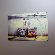 A piece of tempered glass wall art featuring a colorful graffiti print with text and vivid details, hung on a wall.