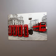 A tempered glass wall art featuring a high-resolution print of red telephone boxes and a bus on a street, with a high-gloss finish.