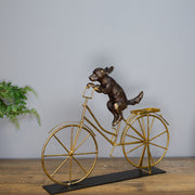 Dog Riding A Bicycle Sculpture
